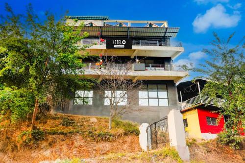 a building with a balcony on top of it at Hotel O Bhowali Nainital Near Graphic Era Hill University in Nainital