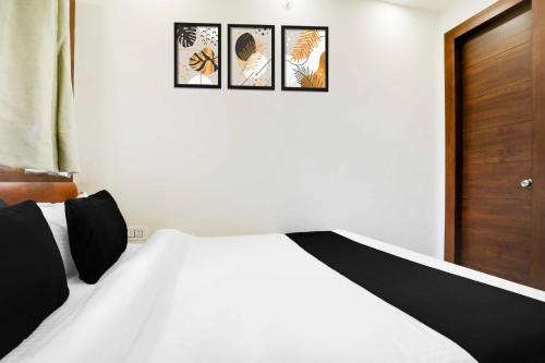 a bedroom with a bed with four pictures on the wall at Hotel O Mall Road Nainital in Nainital