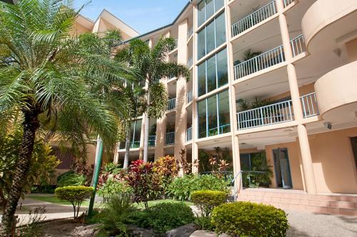 a building with palm trees in front of it at Alexandra on the Pacific in Mooloolaba