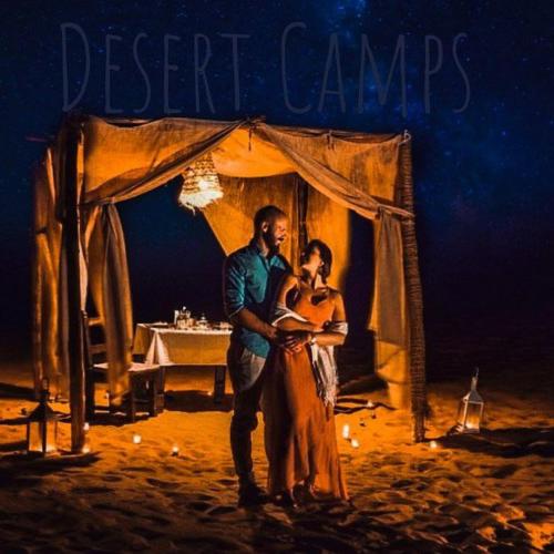 a man and a woman standing under a tent at Sahara Soul luxury Camp in Merzouga