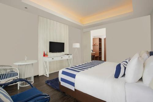 a hotel room with a bed and a television at Swiss-Belresort Belitung in Tanjungbinga