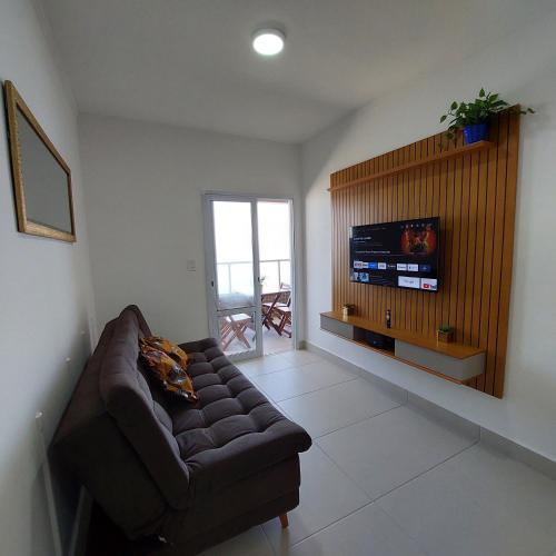 a living room with a couch and a flat screen tv at Apartamento Frente para o Mar em Praia Grande - Vista Incrível in Praia Grande