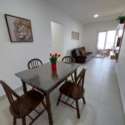 a dining room and living room with a table and chairs at Apartamento Frente para o Mar em Praia Grande - Vista Incrível in Praia Grande