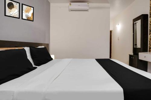 a black and white bed in a room at Hotel O Morjim in Morjim