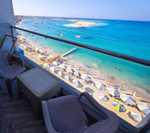 a view of a beach with umbrellas and the ocean at Hostmark Blue Beach Hotel in Marsa Matruh