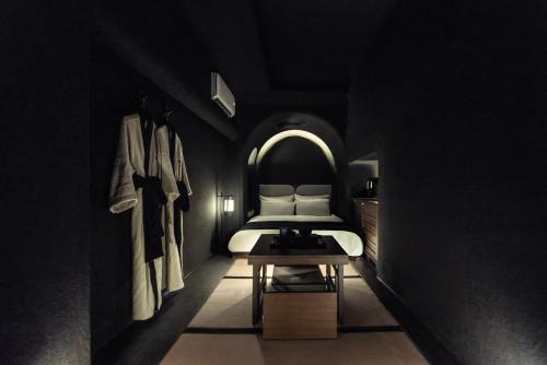 a black room with a bed and a table at Cave Ryokan Hotel by Aank Sungshin Women's University in Seoul