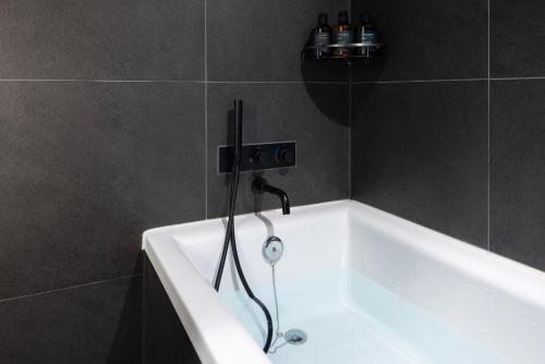 a bath tub with a shower in a bathroom at Cave Ryokan Hotel by Aank Sungshin Women's University in Seoul