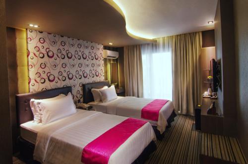 a hotel room with two beds and a window at Eloisa Royal Suites in Mactan