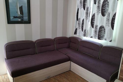 - un canapé dans une pièce avec fenêtre dans l'établissement Mobil home with pool in Dinard, à Dinard