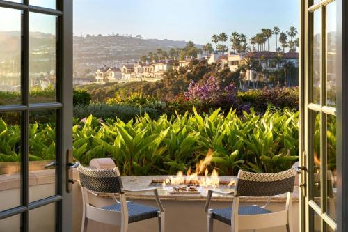 a patio with a table and chairs and a view of a garden at The Ritz-Carlton, Laguna Niguel in Dana Point