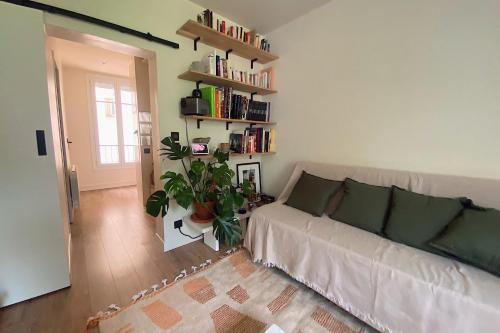 un salon avec un canapé et une étagère dans l'établissement Charming apartment at the gates of Paris, à Boulogne-Billancourt