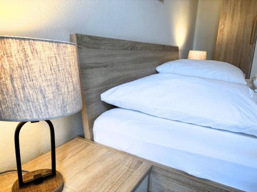 una camera da letto con un letto e una lampada su un tavolo di Lieselotte Strandklamotte a Wulfen auf Fehmarn
