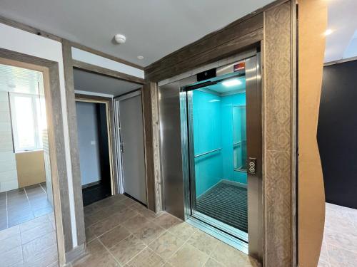 a elevator in a building with a blue door at Chambres côté mer du bouquet in Cosqueville
