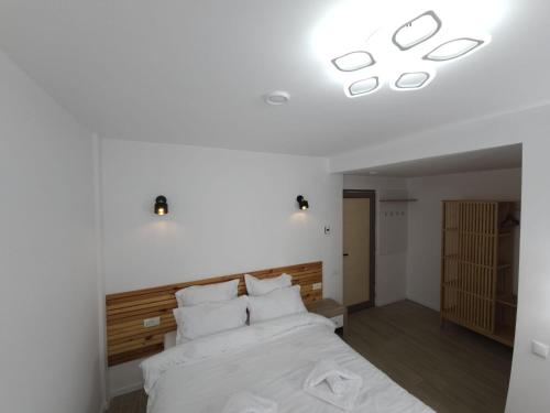a bedroom with a large white bed with white pillows at La Oprescu in Azuga