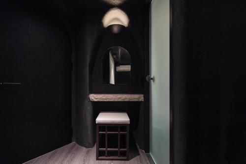 a black bathroom with a stool and a mirror at Cave Ryokan Hotel by Aank Sungshin Women's University in Seoul
