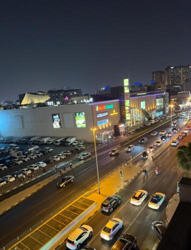 a busy city street at night with cars parked at Palm hostel in Dubai