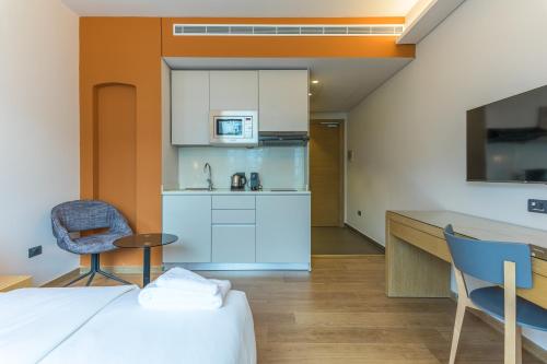 a room with a bed and a kitchen with a table and chairs at Jounieh Living - Residences by Local Host in Ed Dkârîne