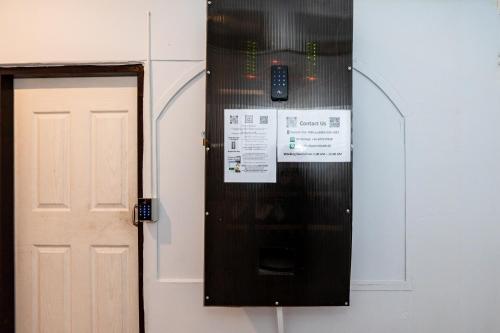 a door to a room with a cell phone on the wall at The Hidden Khaosan เดอะ ฮิดเด้นข้าวสาร in Bang Bua Thong Railway Station