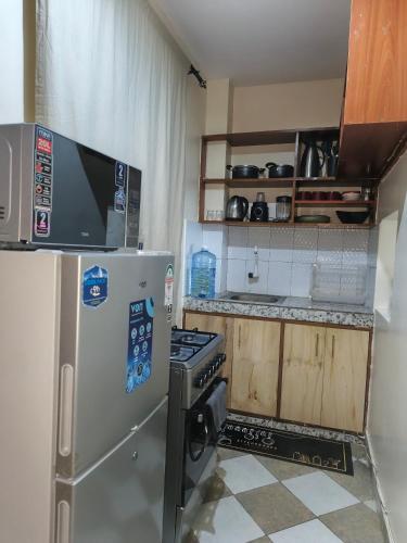 a kitchen with a refrigerator and a stove at Makao in Kilifi