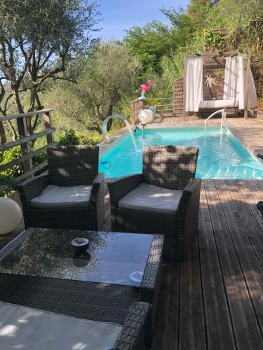 une piscine avec deux chaises et une table à côté d'une terrasse dans l'établissement Cottage Provençal 3 Chambres piscine et spa privés Côte d'Azur très calme campagne proche Nice Monaco et Cannes, à Colomars