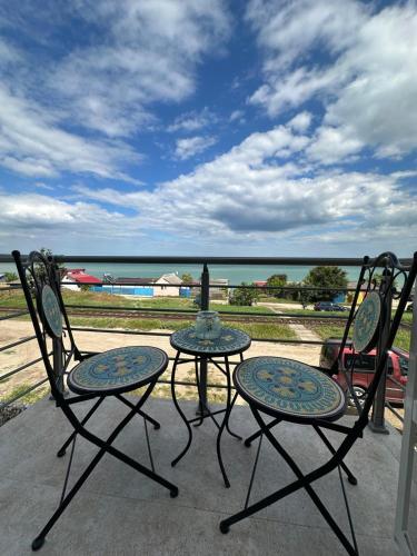 two chairs and a table on a patio overlooking the ocean at Halta Pescăruş Accommodation in Douăzeci şi Trei August