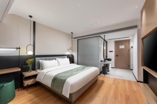 a bedroom with a large bed and a television at KSpace KaiShi hotel in Guangzhou