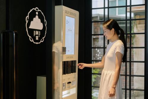 a woman standing in front of a vending machine at Cave Ryokan Hotel by Aank Sungshin Women's University in Seoul