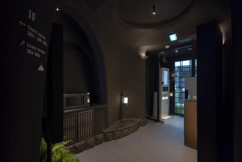 a room with a hallway with a microwave and a door at Cave Ryokan Hotel by Aank Sungshin Women's University in Seoul