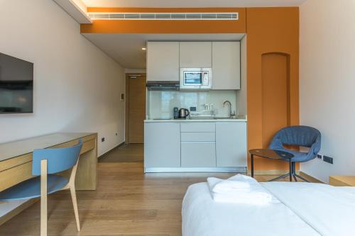 a kitchen and a bedroom with a bed and chairs at Jounieh Living - Residences by Local Host in Ed Dkârîne