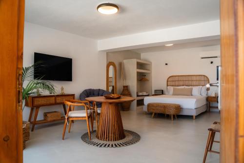 a hotel room with a bed and a table and a bedroom at Divino Caldera in Akrotiri