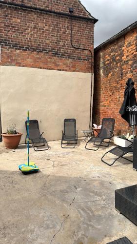 a patio with three chairs and a mop at Large 4 bedroom house in Sleaford