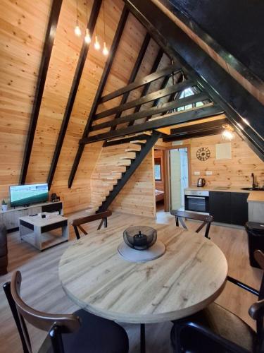 a wooden table and chairs in a room with a staircase at Boričje Hidden Paradise in Pluzine