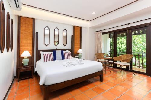 a bedroom with a bed and a table and chairs at Rimping Village in Chiang Mai