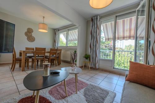 a living room with a couch and a table at Le Fernand - Campus - Parking in Saint-Martin-dʼHères