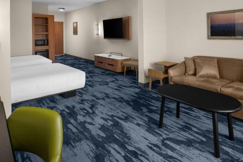 a hotel room with a bed and a couch at Fairfield by Marriott Inn & Suites Winters Davis in Winters