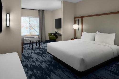 a hotel room with a large bed and a desk at Fairfield by Marriott Inn & Suites Winters Davis in Winters
