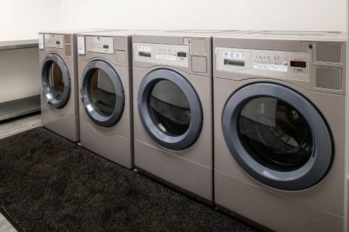 three washing machines are lined up in a room at Fairfield by Marriott Inn & Suites Winters Davis in Winters