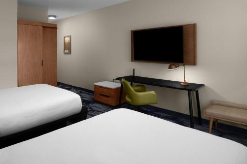 a hotel room with two beds and a desk and a chair at Fairfield by Marriott Inn & Suites Winters Davis in Winters