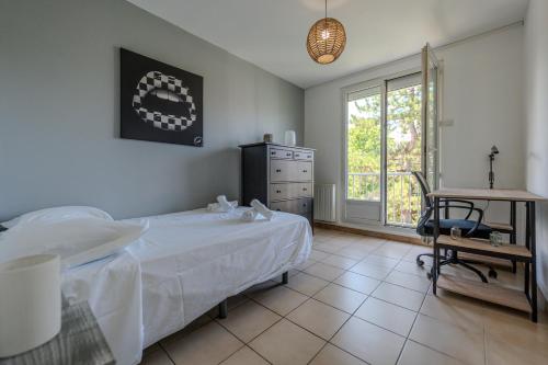 a bedroom with a bed and a desk and a window at Le Fernand - Campus - Parking in Saint-Martin-dʼHères