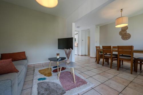 a living room with a couch and a dining room at Le Fernand - Campus - Parking in Saint-Martin-dʼHères