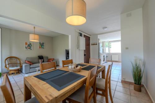a dining room and living room with a table and chairs at Le Fernand - Campus - Parking in Saint-Martin-dʼHères