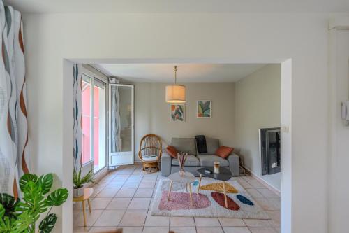 a living room with a couch and a table at Le Fernand - Campus - Parking in Saint-Martin-dʼHères