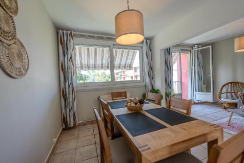 a dining room with a wooden table and chairs at Le Fernand - Campus - Parking in Saint-Martin-dʼHères