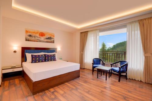 a bedroom with a bed and a table and chairs at Keys Select by Lemon Tree Hotels, Kufri, Shimla in Shimla
