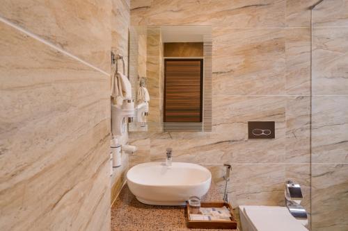 a bathroom with a white sink and a mirror at Keys Select by Lemon Tree Hotels, Kufri, Shimla in Shimla