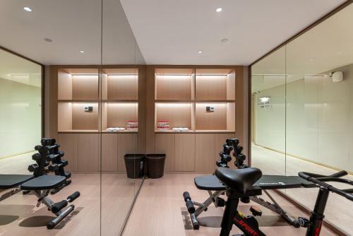a gym with exercise equipment and glass walls at KSpace KaiShi hotel in Guangzhou