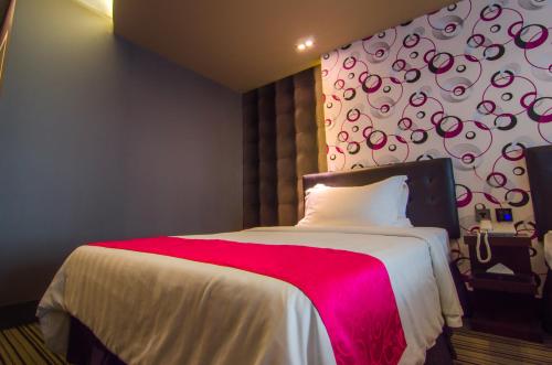 a bedroom with a large bed with a red blanket at Eloisa Royal Suites in Mactan