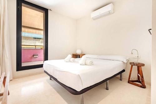 a white bedroom with a bed and a window at Vilassar del Mar - Turistea in Vilassar de Mar