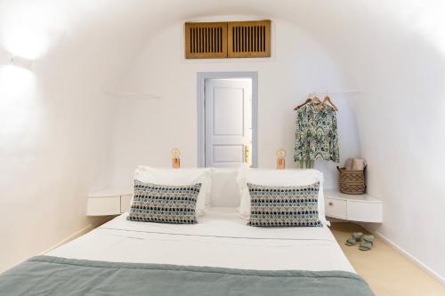 una camera con un letto e due sedie bianche di El Verano Sunset a Imerovigli