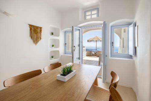 una sala da pranzo con tavolo e sedie in legno di El Verano Sunset a Imerovigli